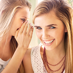 a girl telling a secret to her friend